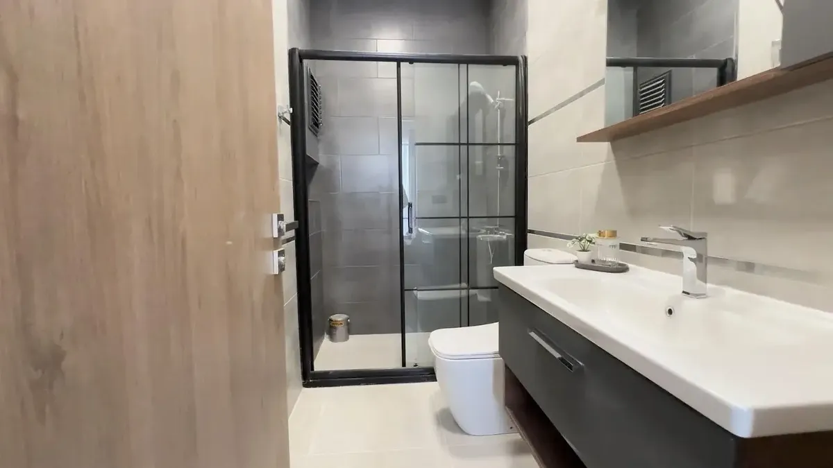 Çekmeköy Emlak Konut, banyo: siyah çerçeveli duşakabin ve antrasit lavabo dolabı
